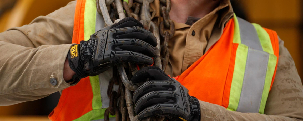 Construction worker carrying chains wearing Mechanix work gloves